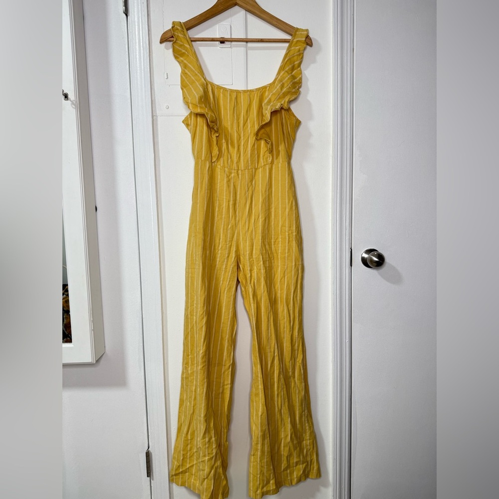 Yellow pinstripe tie back jumpsuit with front ruffle & adjustable straps. Size M